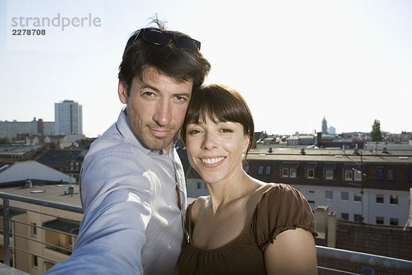 Ein Paar  das sich auf einer Dachterrasse fotografiert.