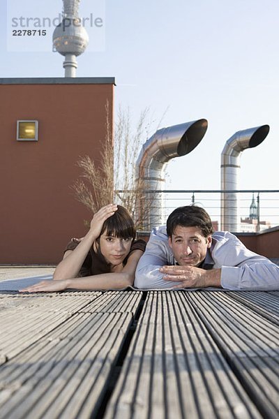 Porträt eines Mannes und einer Frau  die zusammen auf einer Dachterrasse liegen.