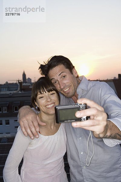 Ein Paar  das sich auf einer Dachterrasse fotografiert.