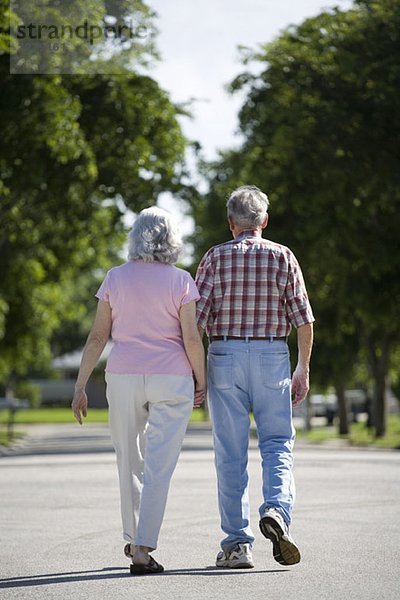 Ein älteres Paar  das eine Straße entlanggeht.