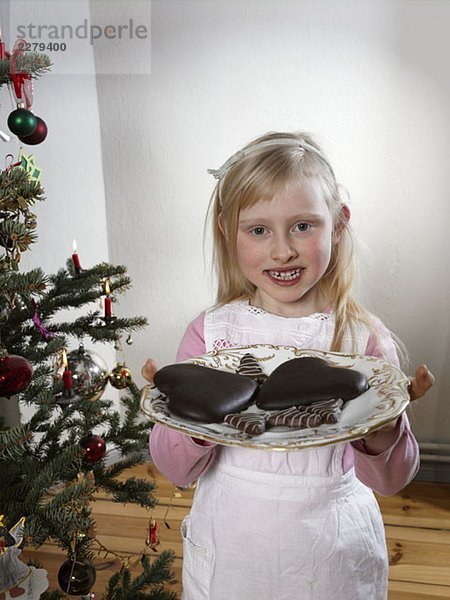 Ein Mädchen mit einem Teller Kekse zu Weihnachten.