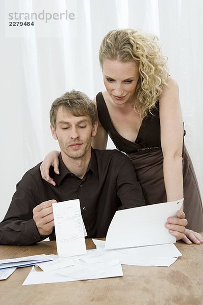Ein mittleres erwachsenes Paar  das die Finanzen zu Hause erledigt.