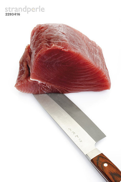 Geschnittener roher Thunfisch mit Messer