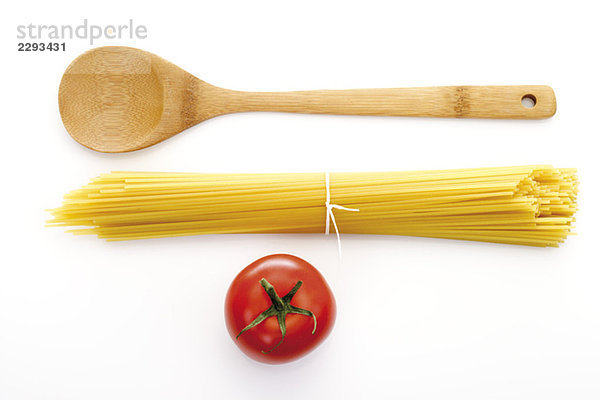 Bündel Spaghetti  Holzlöffel und Tomate  erhöhte Ansicht
