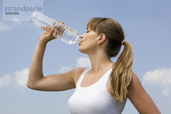 Junge Frau trinkt Wasser  Porträt