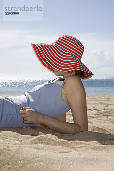 Frau am Strand liegend  Seitenansicht