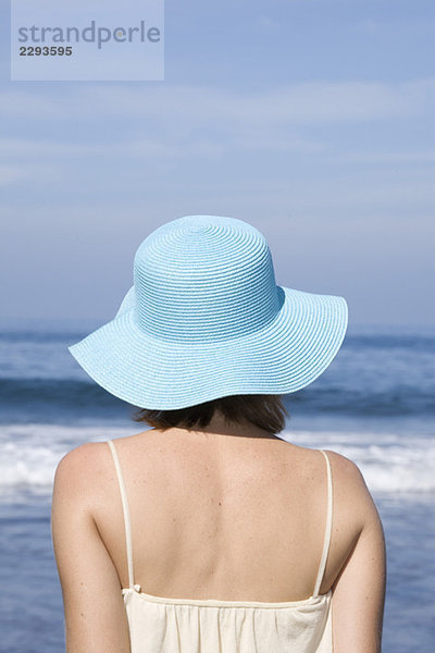 Frau mit Hut am Strand