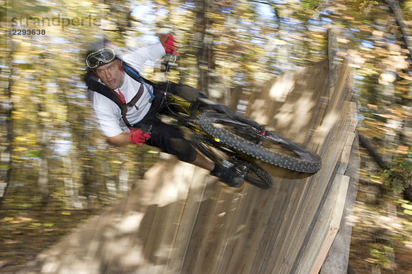 Italien  Südtirol  Bozen  Mountainbiker überwinden ein Hindernis