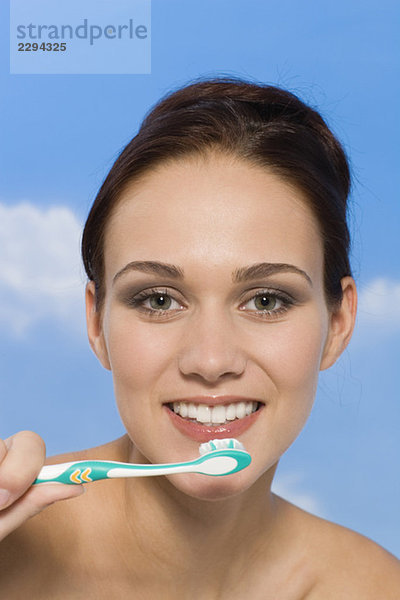 Junge Frau mit Zahnbürste  lächelnd  Porträt