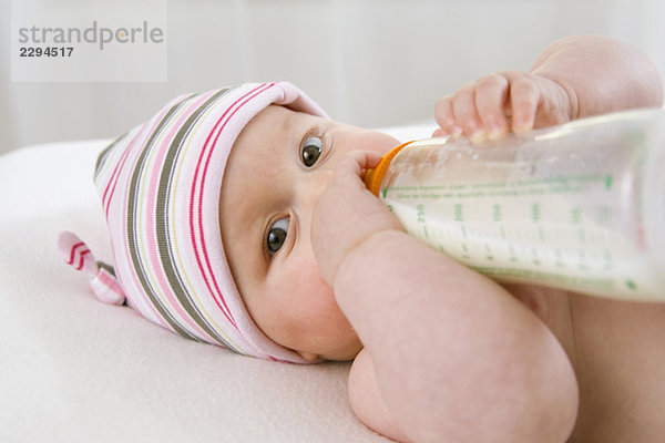 Baby Junge (6-9 Monate) trinkt Milch aus der Flasche  Portrait