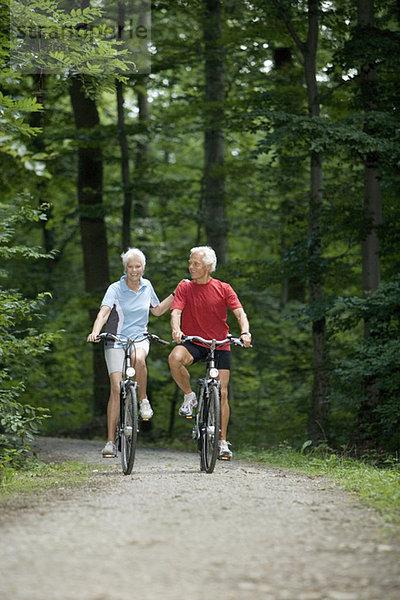 Seniorenpaar Radfahren auf Waldweg