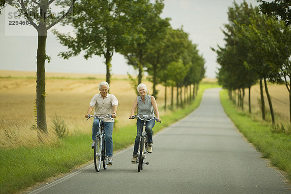 Seniorenpaar Radfahren auf der Landstraße