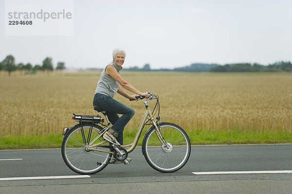 Seniorin beim Radfahren auf der Straße