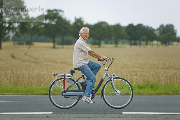 Senior Mann Radfahren auf der Straße