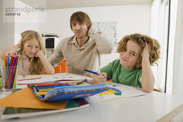 Vater und Kinder bei den Hausaufgaben