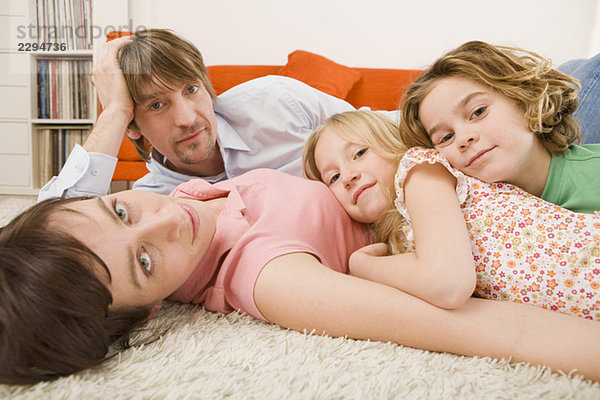 Familie auf dem Boden liegend im Wohnzimmer