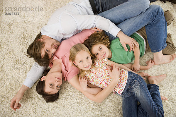 Familie auf dem Boden liegend im Wohnzimmer  erhöhte Aussicht