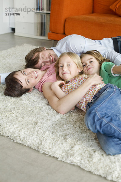 Familie auf dem Boden liegend im Wohnzimmer