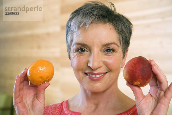 Reife Frau mit Früchten  lächelnd  Portrait