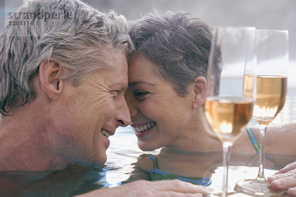 Erwachsenes Paar mit Champagner im Schwimmbad  Portrait