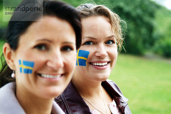 Frauen mit der schwedischen Flagge auf der Wange