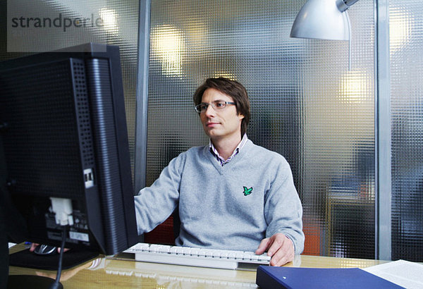 Mann mit Computer bei der Arbeit