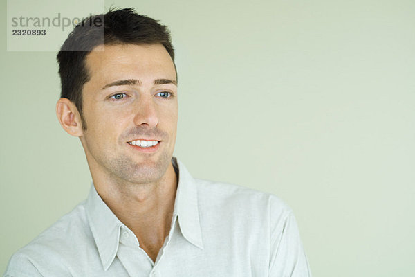 Mann lächelnd  Blick aus dem Rahmen  Kopf und Schultern  Portrait