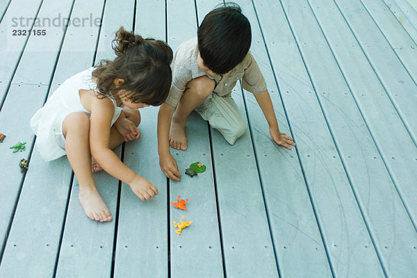 Zwei junge Freunde  die sich zusammenkauern  mit Spielzeug spielen  hohe Blickwinkel