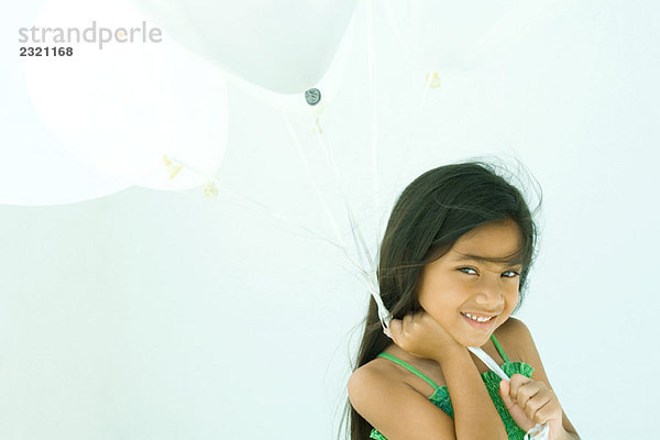 Kleines Mädchen mit Luftballons  lächelnd vor der Kamera  Porträt