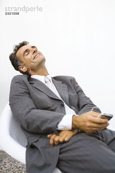 Geschäftsmann entspannt  MP3-Player hören  mit geschlossenen Augen lächeln