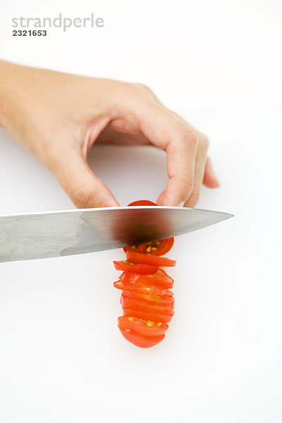 Frau schneidet Tomate mit Messer  Hochwinkelansicht  abgeschnitten