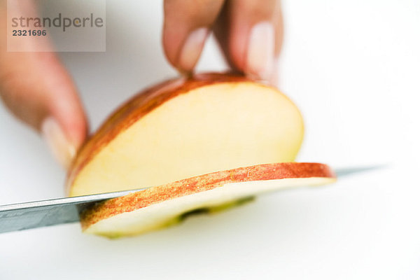 Frau schneidet Apfel mit Messer  abgeschnittene Ansicht der Hand