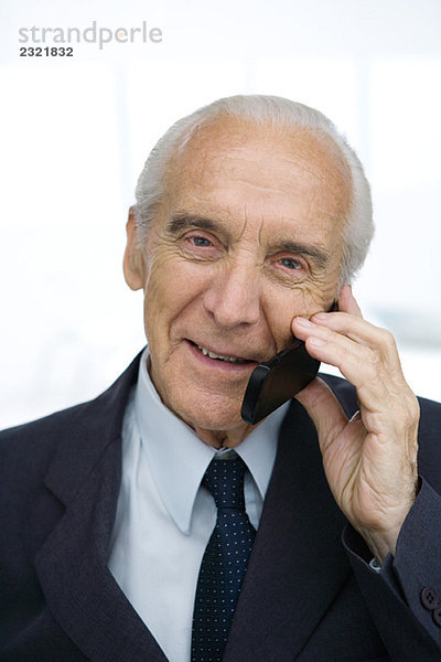 Senior Geschäftsmann mit Handy  lächelnd  Portrait