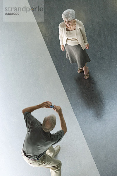 Mann fotografiert Frau mit Digitalkamera  von oben gesehen