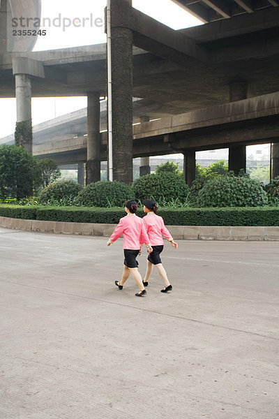 China  Guangzhou  zwei Frauen in passenden Uniformen unter der Brücke  Rückansicht