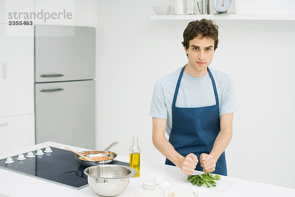 Junger Mann beim Kochen in der Küche
