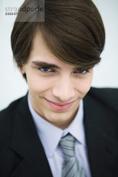 Junger Mann im Anzug lächelnd vor der Kamera  Porträt