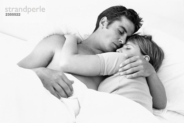 Paar im Bett umarmend  Augen geschlossen