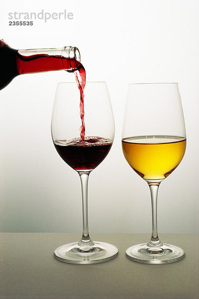 Zwei Weingläser  Rotwein in das eine  Weißwein in das andere gegossen