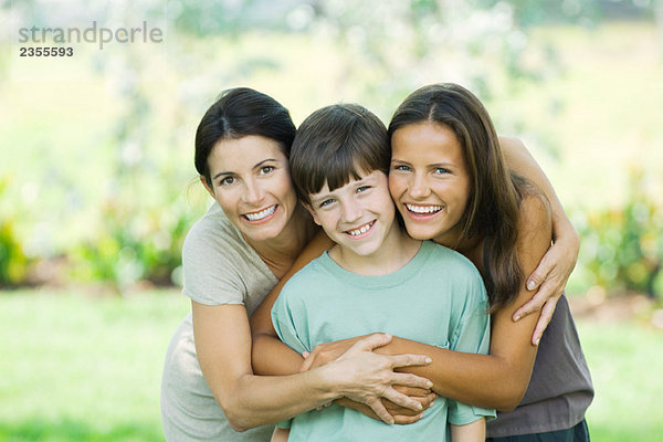 Mutter mit Sohn und jugendlicher Tochter  lächelnd vor der Kamera  Porträt