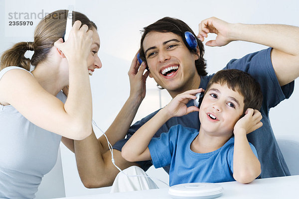Familie  die gemeinsam CD-Player hört  Vater und Sohn über drahtlose Kopfhörer