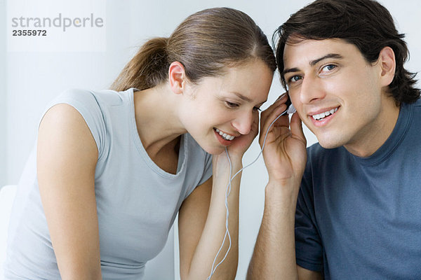 Paar  die zusammen Kopfhörer hören  lächeln