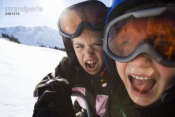 Kinder in Skihelmen und Skibrille