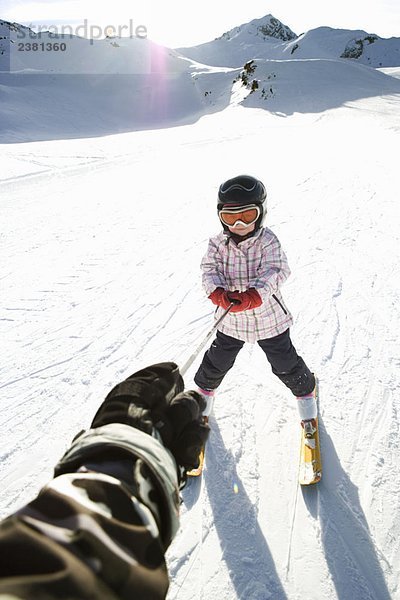 Junges Mädchen wird auf Skiern geschleppt
