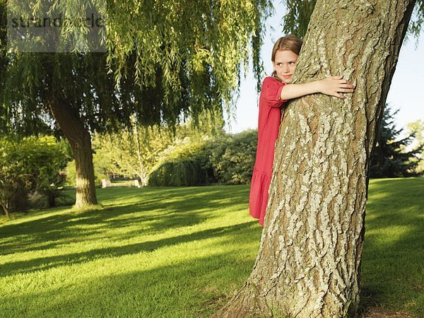 Junges Mädchen umarmt Baum