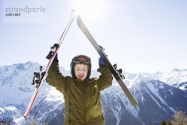 Junge mit Skiern über dem Kopf