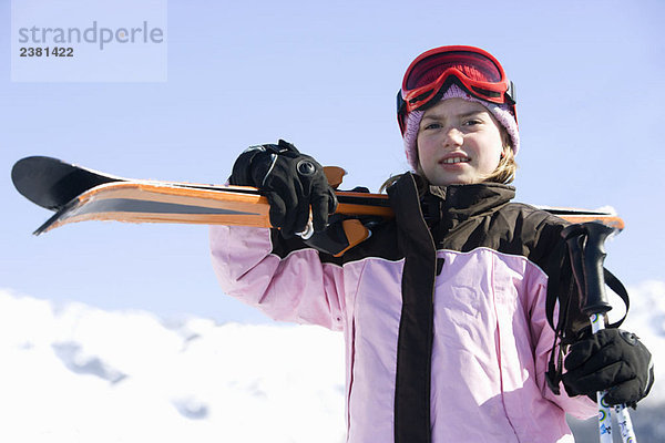 Mädchen mit Skiern auf der Schulter