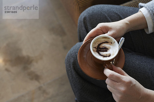 Frau mit Cappuccino mit Euro-Motiv