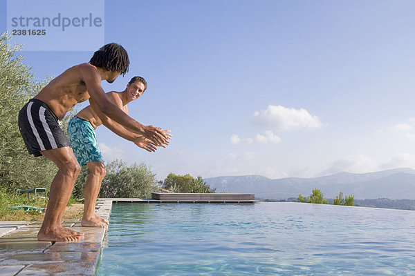 Junge Männer  die in einen Pool springen