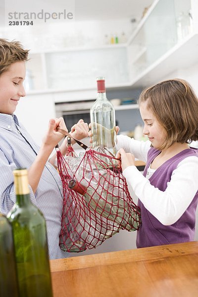 Junge und Mädchen recyceln leere Flaschen